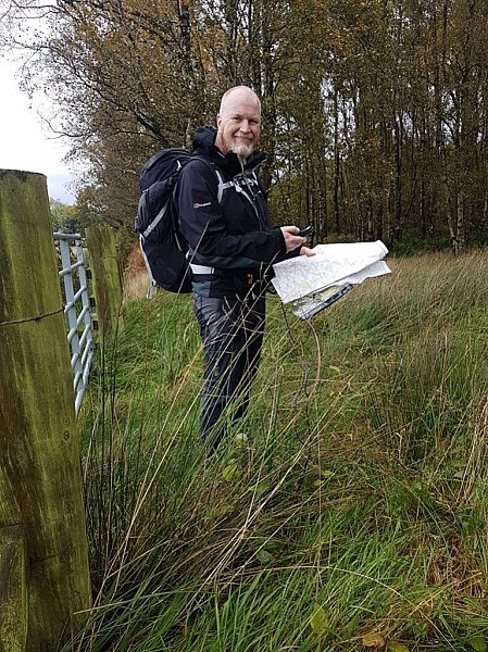 Chairman in field looking at map